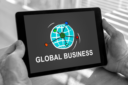 Male hands holding a tablet with global business conceptの写真素材