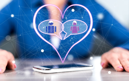 Smartphone with online dating concept between hands of a woman in backgroundの写真素材