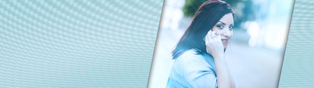 Portrait of pretty young woman talking on mobile phone outdoors, light effect. panoramic banner