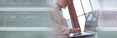 Senior businessman using laptop, light effect. panoramic bannerの写真素材