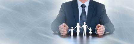 Insurer protecting a family with his hands. panoramic bannerの写真素材