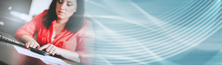 Young businesswoman using a calculator at office. panoramic bannerの写真素材