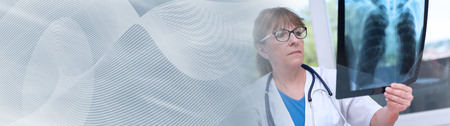 Female doctor examining x-ray report in medical office. panoramic banner
