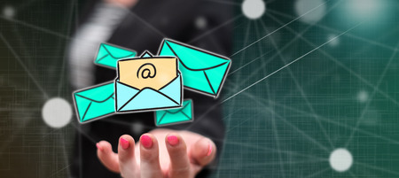 E-mail concept above the hand of a woman in backgroundの写真素材