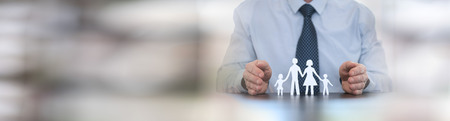 man protecting a family with his hands. panoramic bannerの写真素材