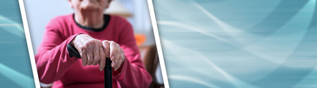Old woman sitting with her hands on a cane. panoramic bannerの写真素材