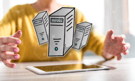 Digital tablet with desktop computer concept between hands of a woman in backgroundの写真素材