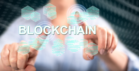 Woman touching a blockchain concept on a touch screen with her fingersの写真素材