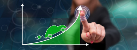 Woman touching an electric car increase concept on a touch screen with her fingerの写真素材