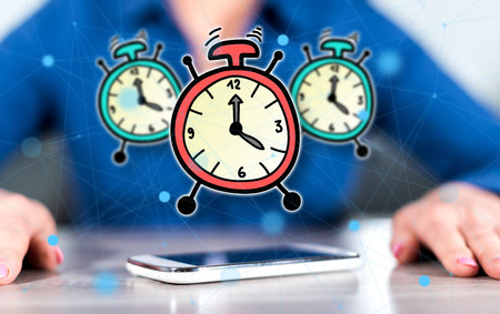 Smartphone with time concept between hands of a woman in background