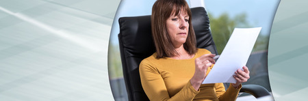 Mature businesswoman checking document in office. panoramic bannerの写真素材