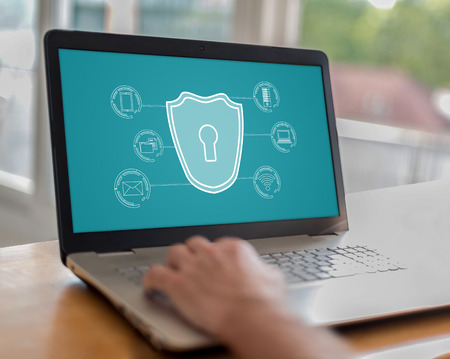 Man using a laptop with cyber security concept on the screen