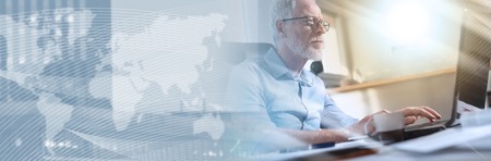 Portrait of senior businessman working on laptop in office, light effect. panoramic banner