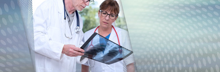 Two doctors examining x-ray report in medical office. panoramic bannerの写真素材