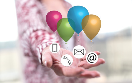 Contact concept above the hand of a woman in backgroundの写真素材