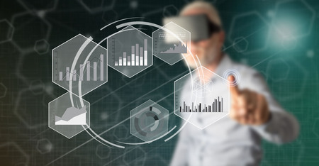 Man with vr headset touching a data analysis concept on a touch screen with his fingerの写真素材