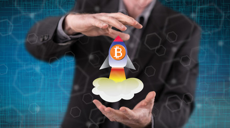 Bitcoin rise concept between hands of a man in backgroundの写真素材