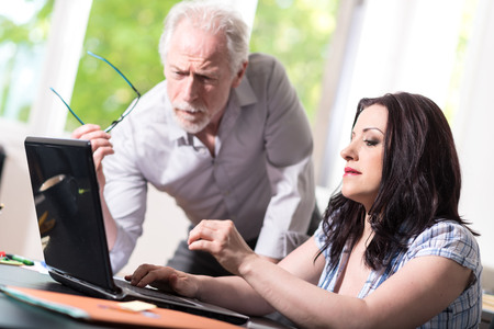 Young businesswoman and senior businessman working together at officeの写真素材
