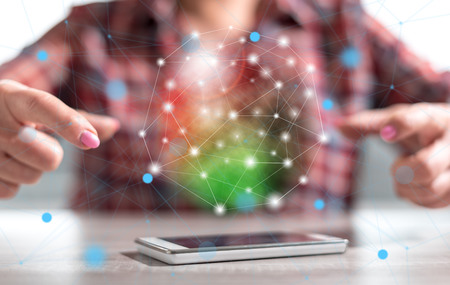 Smartphone with network concept between hands of a woman in background