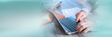 Male hands using a laptop in office. panoramic banner