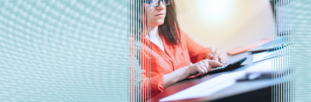 Young businesswoman using a calculator at office, light effect. panoramic banner