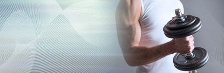 Athletic man working with heavy dumbbell. panoramic bannerの写真素材