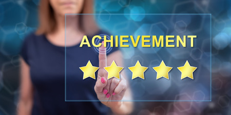 Woman touching an achievement concept on a touch screen with her fingerの写真素材