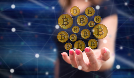 Bitcoin currency concept above the hand of a woman in backgroundの写真素材