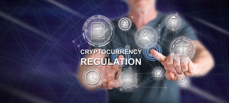 Man touching a cryptocurrency regulation concept on a touch screen with his fingersの写真素材