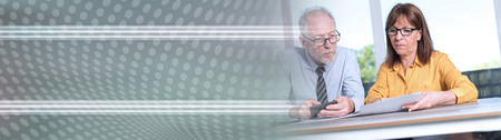 Two mature business people working together in office. panoramic banner