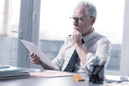 Businessman checking a document in officeの写真素材