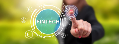 Woman touching a fintech concept on a touch screen with her fingerの写真素材