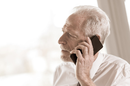 Portrait of senior businessman talking on mobile phoneの写真素材