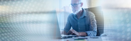 Portrait of senior businessman working on laptop in office, light effect, double exposure. panoramic...