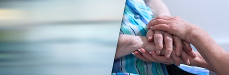 Hands of young woman holding the hands of an elderly person. panoramic bannerの写真素材
