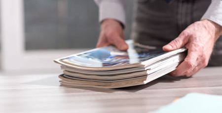 Hands of businessman holding magazinesの写真素材
