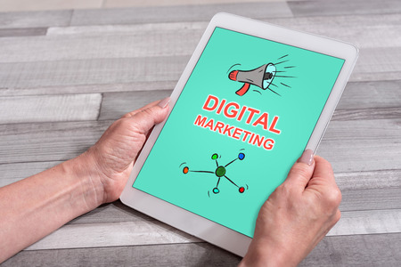 Female hands holding a tablet with digital marketing conceptの写真素材