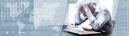 Stressed businessman sitting in office with head in hands. panoramic banner