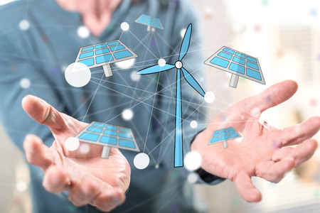 Green energy concept above the hands of a man in backgroundの写真素材