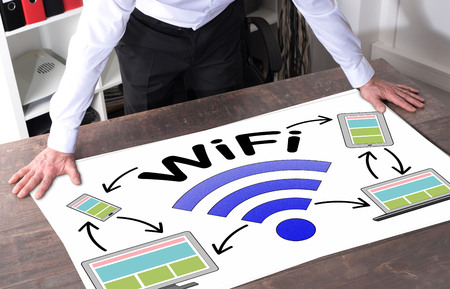 Man watching a wifi concept placed on a deskの写真素材