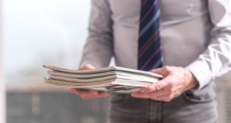Hands of businessman holding magazinesの写真素材