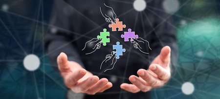 Teamwork concept above the hands of a man in backgroundの写真素材