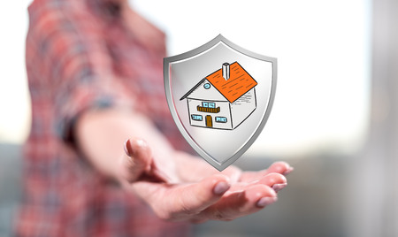 House protection concept above the hand of a woman in backgroundの写真素材