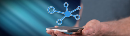 Network concept above a smartphone held by a man