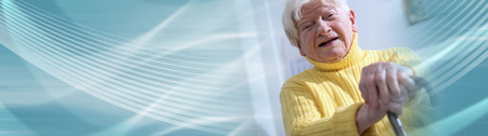 Old woman sitting with her hands on a cane. panoramic bannerの写真素材