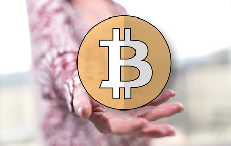 Bitcoin concept above the hand of a woman in backgroundの写真素材