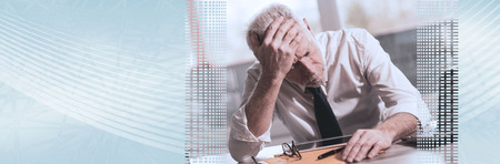 Stressed businessman sitting in office with hand on forehead. panoramic banner