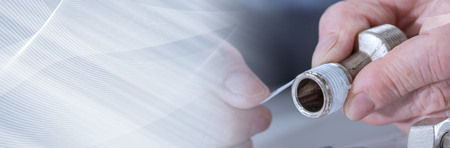 Plumber putting a sealing tape on a thread, closeup. panoramic bannerの写真素材