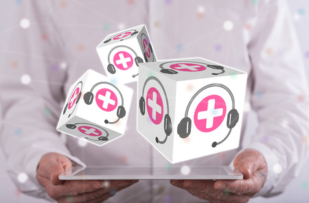 Online medical support concept above a tablet held by a man in backgroundの写真素材