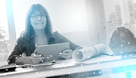 Portrait of female architect working on plans at office, light effectの写真素材